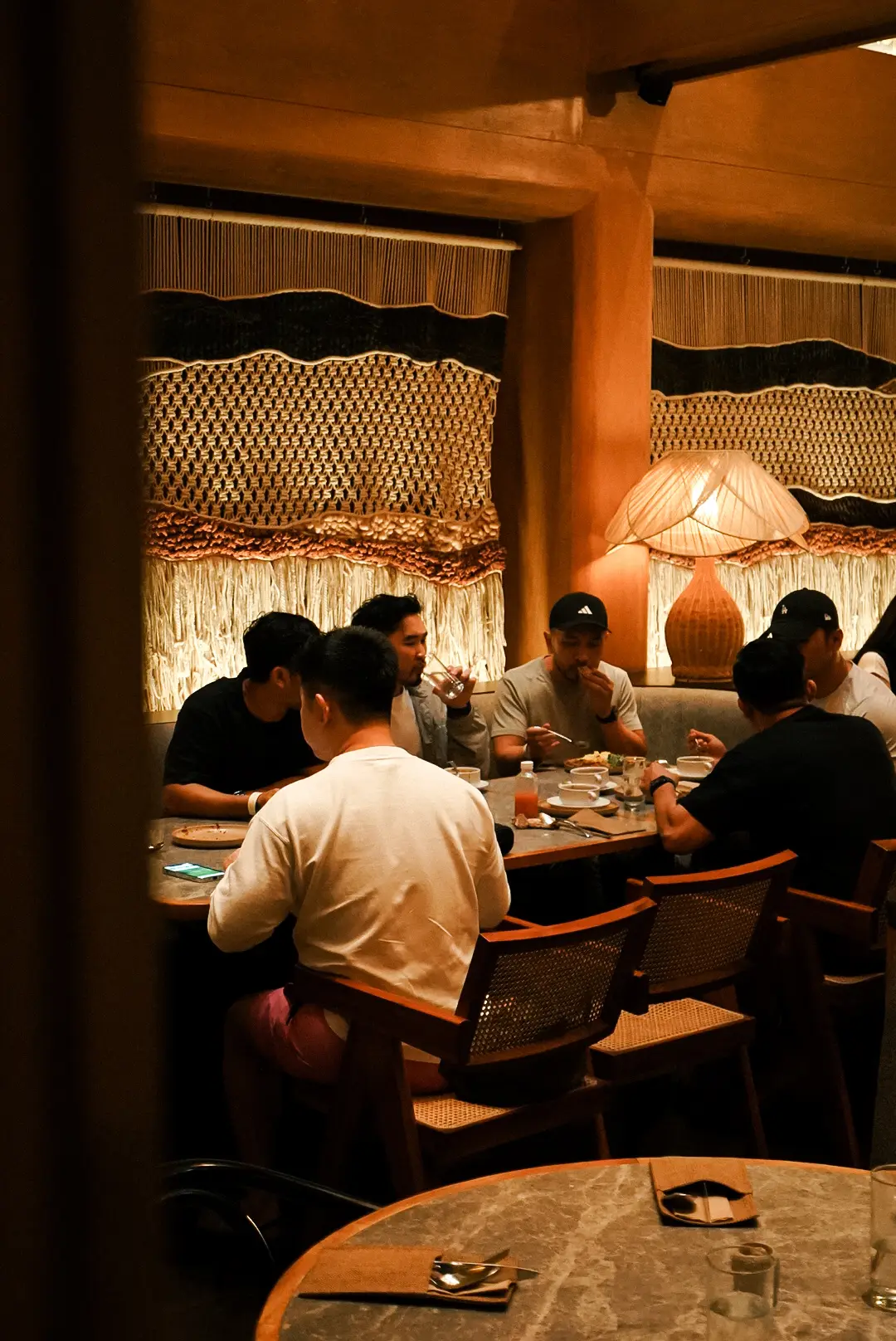 The warm dining room at Semaja, with woven wall art and rattan lighting